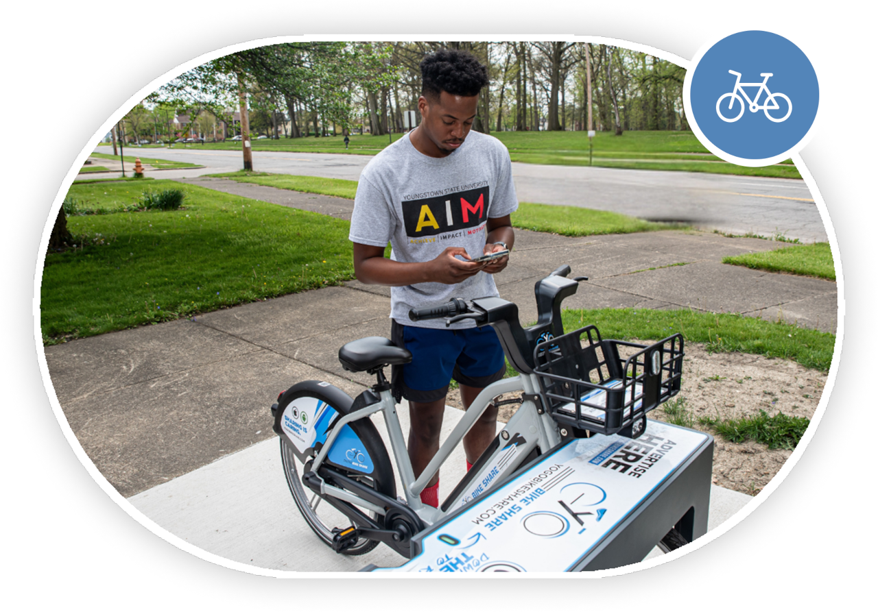 A young African American bicyclist using their phone to checkout an e-bike