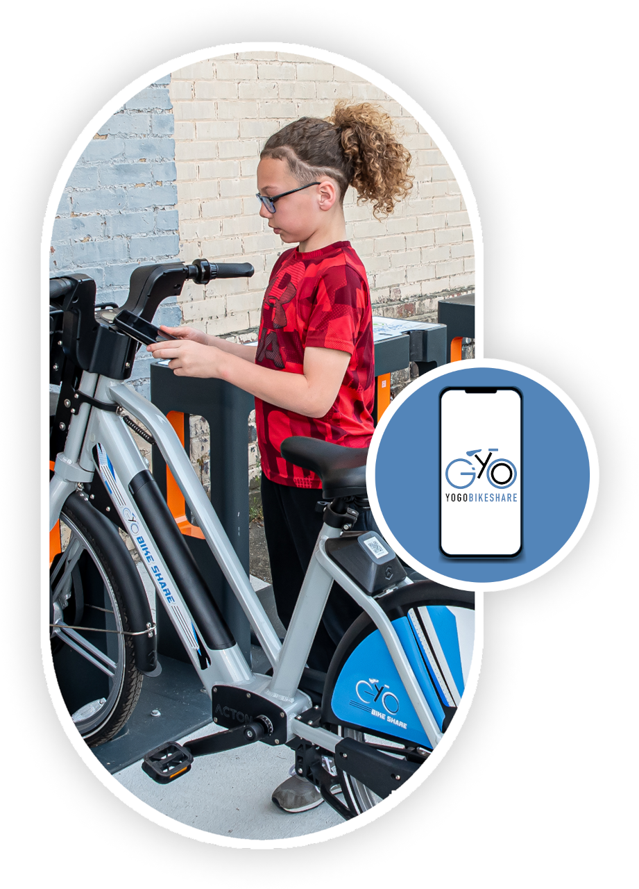 A young child in a red shirt preparing to ride an e-bike